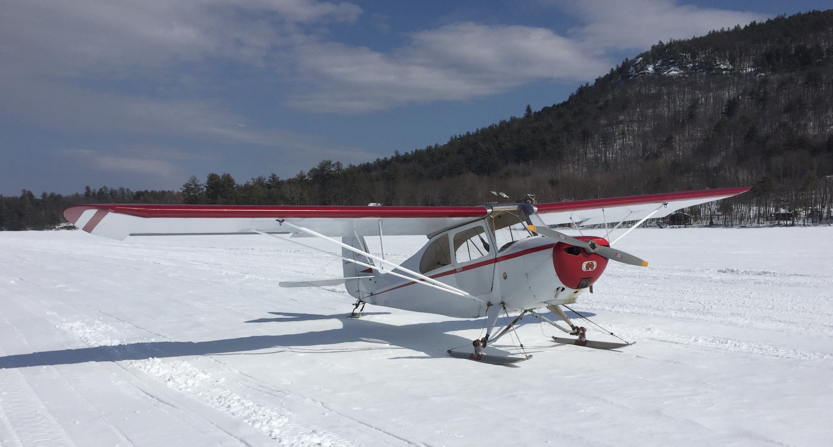 Aeronca Champ on skis parked on a frozen lake in winter